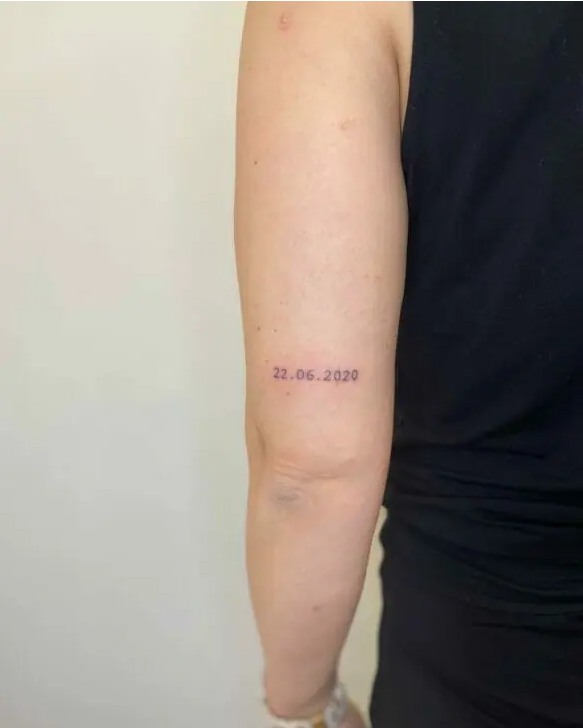 date tattoo on elbow