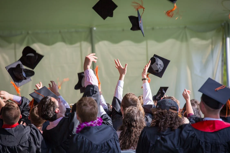 PhD Scholars celebrating their degree with flying caps in the air 