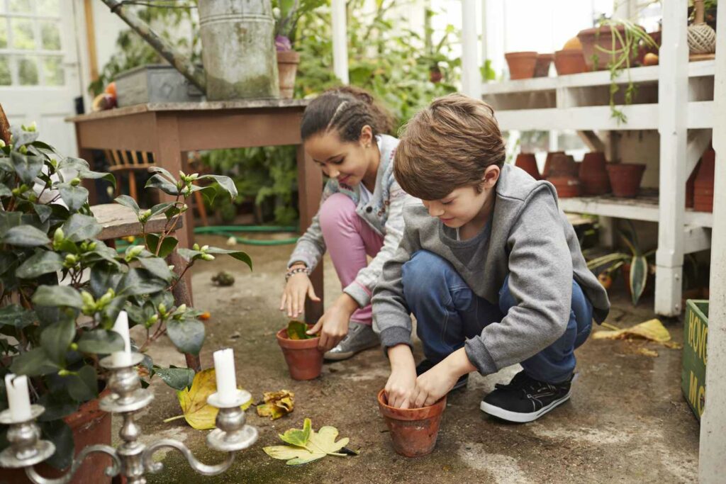Photo of a boy and a girl in the garden; gardening is one of the easy jobs for 8 year olds